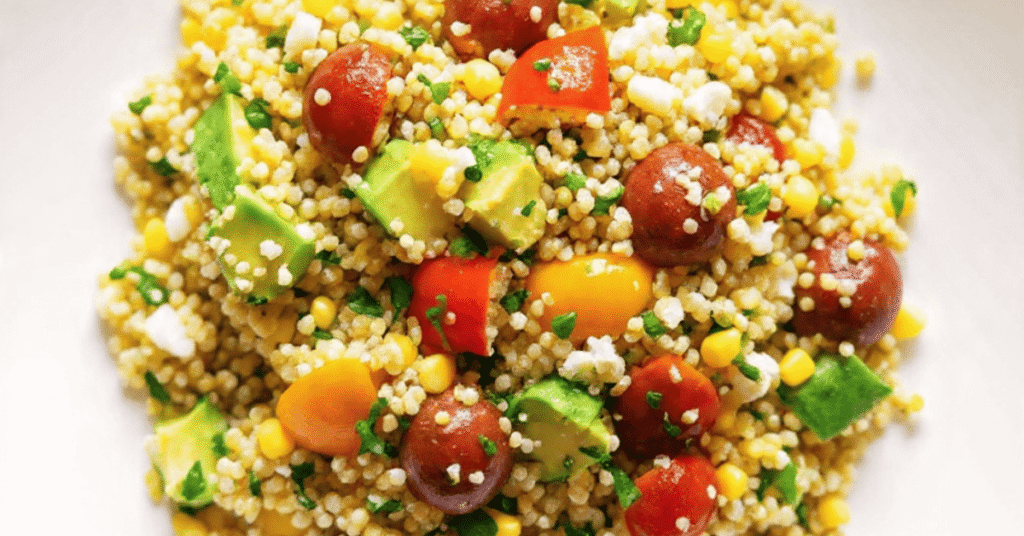 Vibrant avocado blueberry quinoa salad in a white bowl with toasted pepitas and fresh mint