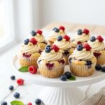 heesecake cupcakes with berry topping on a cake stand
