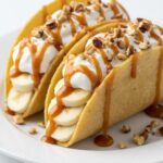 Overhead view of caramel banana nuts tacos with whipped cream and nuts