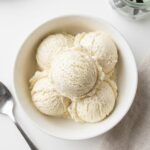 Overhead shot of homemade vanilla ice cream in a white bowl.