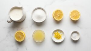 Flat lay of all ingredients for lemon posset on white marble.