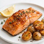 Plated hot honey salmon with roasted potatoes and lemon