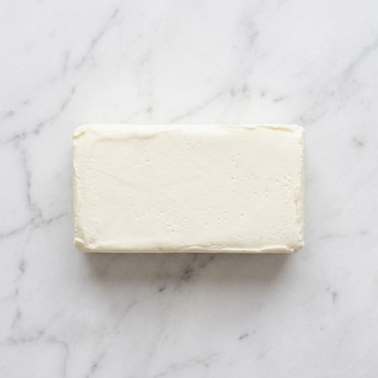 Block of cream cheese on marble surface