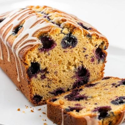 Sliced lemon blueberry bread arranged in an overhead flat lay on a white plate.