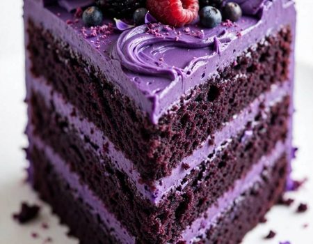 Purple velvet cake recipe with glossy frosting and berry topping