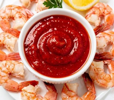 Best homemade cocktail sauce recipe in white ceramic bowl with fresh shrimp on bright white table