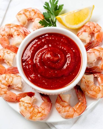 Best homemade cocktail sauce recipe in white ceramic bowl with fresh shrimp on bright white table