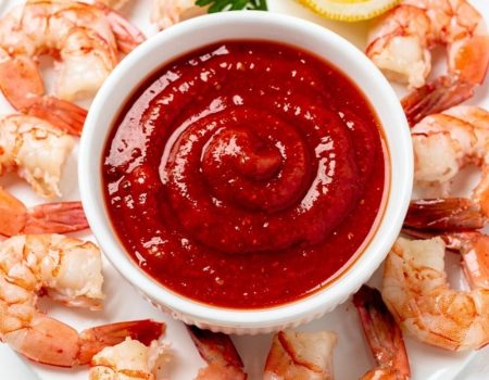 Best homemade cocktail sauce recipe in white ceramic bowl with fresh shrimp on bright white table