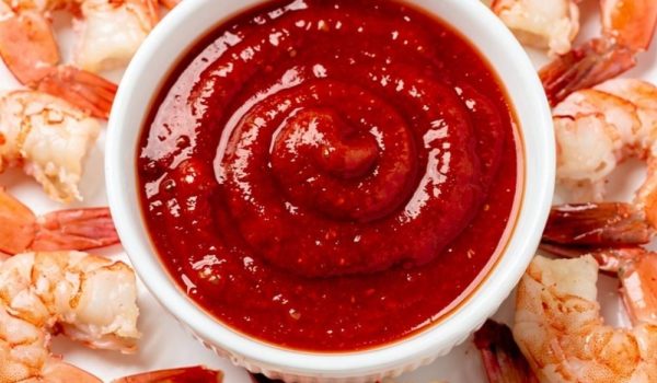 Best homemade cocktail sauce recipe in white ceramic bowl with fresh shrimp on bright white table