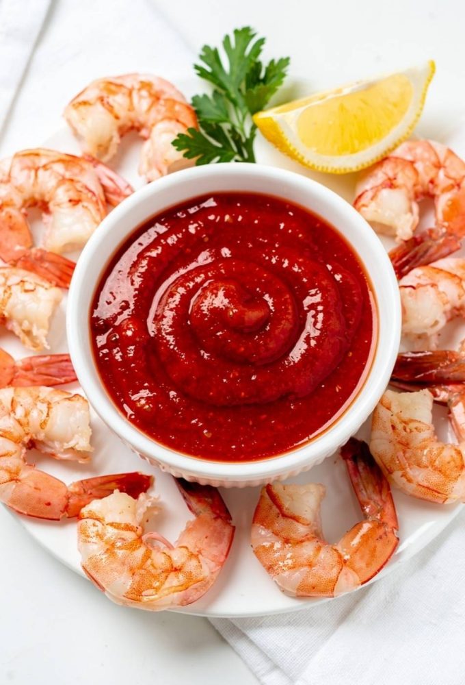 Best homemade cocktail sauce recipe in white ceramic bowl with fresh shrimp on bright white table