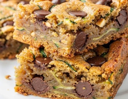 Almond butter chocolate chip zucchini bars arranged neatly on a white plate.