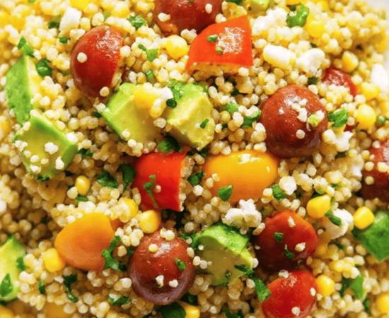 Vibrant avocado blueberry quinoa salad in a white bowl with toasted pepitas and fresh mint