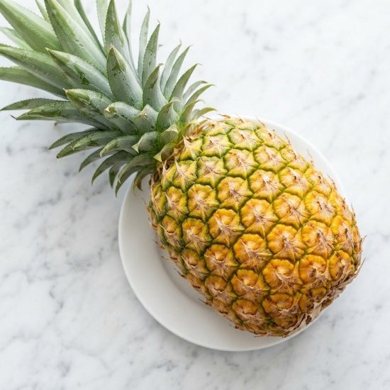 Fresh pineapple on a white marble surface