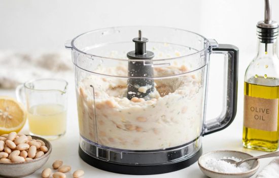 Blending cannellini beans into a smooth pesto white bean puree.