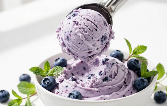 Serving a scoop of finished blueberry frozen yogurt.