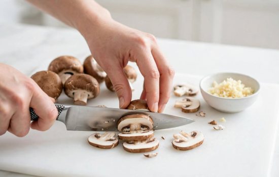 Slicing fresh mushrooms and mincing garlic for creamy mushroom fettuccine.