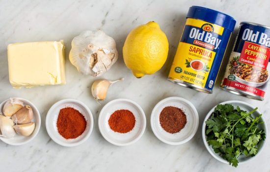 all seafood boil sauce ingredients laid out on a white table, bright overhead food photography