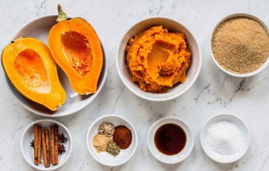 Step 1 of Pumpkin Butter — all ingredients arranged in white bowls on a white marble table, fresh pumpkin, puree, brown sugar, spices, vanilla, salt