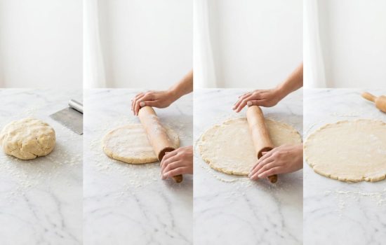 Chilled pie dough being rolled on a lightly floured surface.