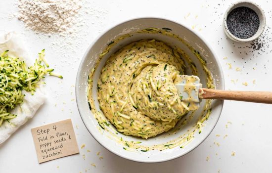 Folding zucchini and poppy seeds into muffin batter