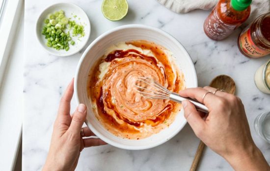 Whisking Bang Bang sauce ingredients together in a white bowl, step 1