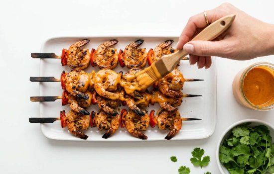 Brushing Bang Bang sauce over grilled shrimp skewers, step 5
