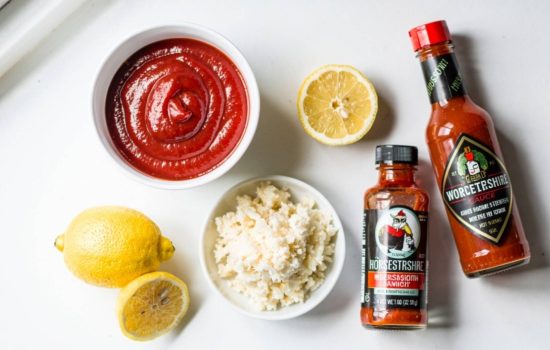 All cocktail sauce ingredients gathered and laid out on a white table ready to prepare.