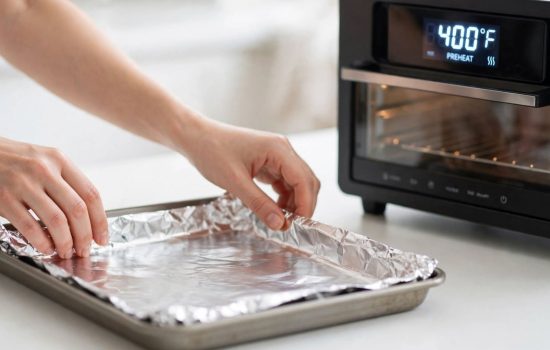 Lining a baking sheet with foil before baking salmon.