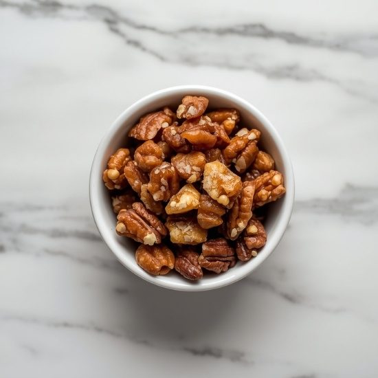 Toasted chopped pecans and walnuts in a white bowl