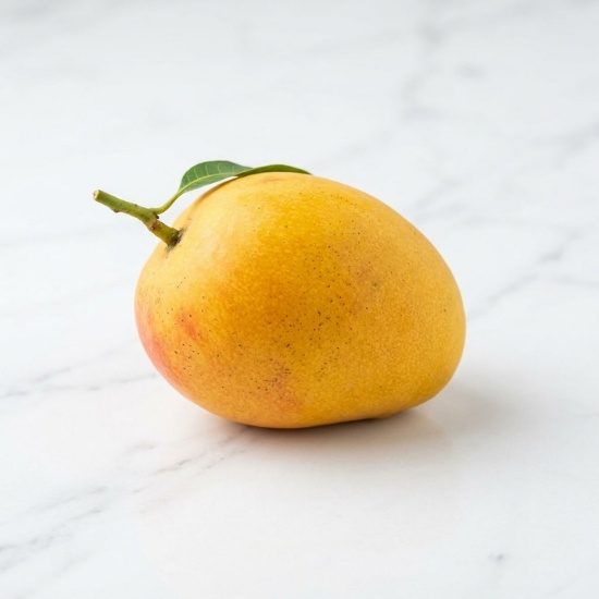 Fresh mango on a white marble surface